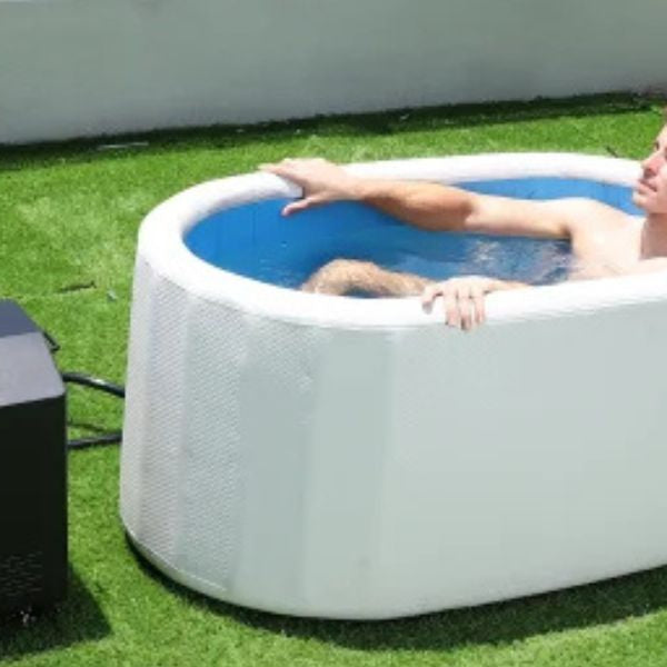 Man relaxing in a cold plunge tub connected to a water chiller, showing consistent cold therapy without ice