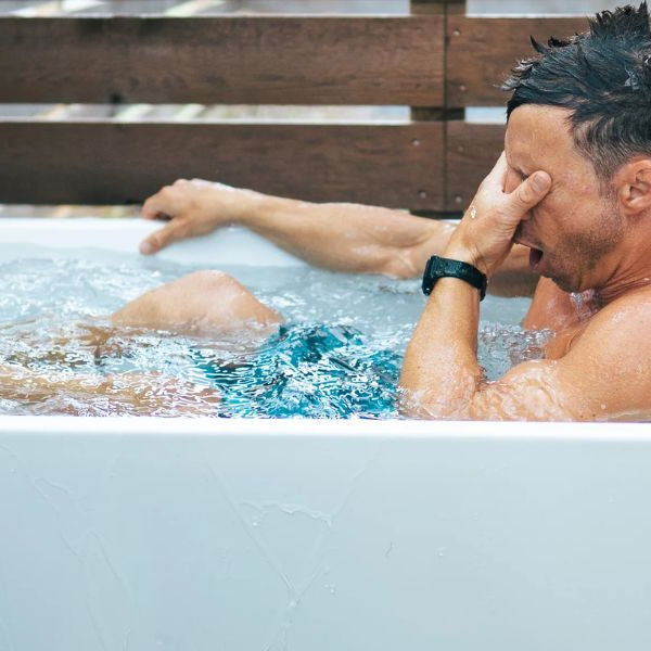 Man reacting to cold water immersion in a home cold plunge tub, demonstrating real experience and recovery benefits