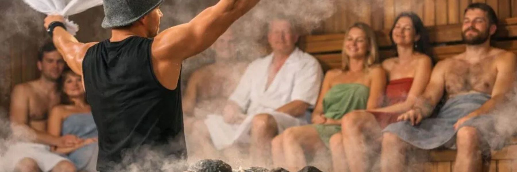 People enjoying sauna steam session with towel waving, showing heat therapy and group wellness experience