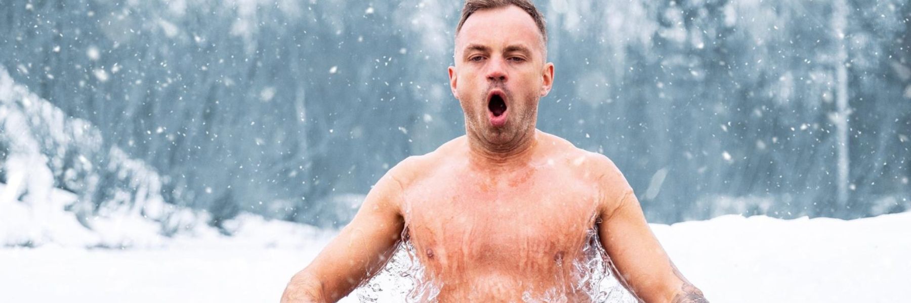 Man entering freezing lake water in winter showing the cold shock response during ice swimming.