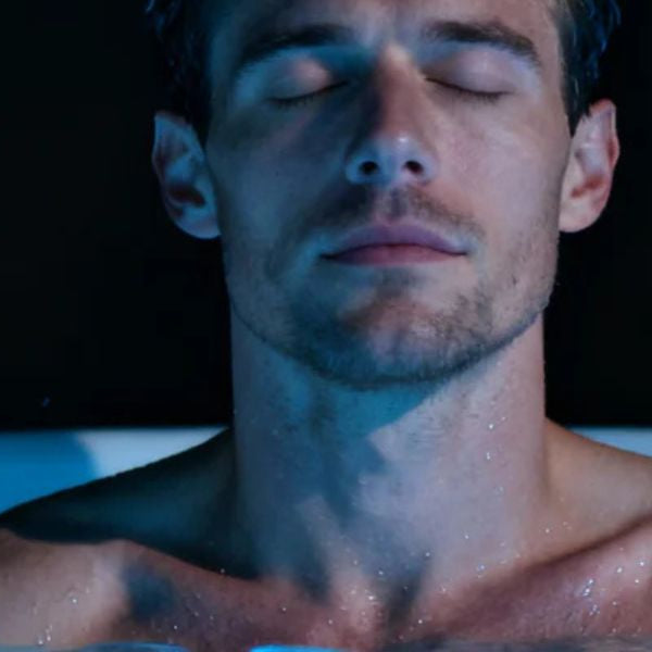 Man relaxing in an ice bath with eyes closed, demonstrating cold plunge therapy for stress relief and mental clarity