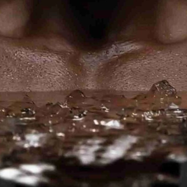 Close-up of a person’s chest submerged in an ice bath with floating ice cubes during cold plunge therapy.
