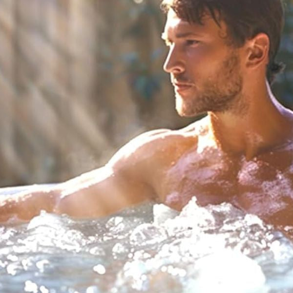 Person sitting in a cold plunge tub during an ice bath session for recovery and wellness.