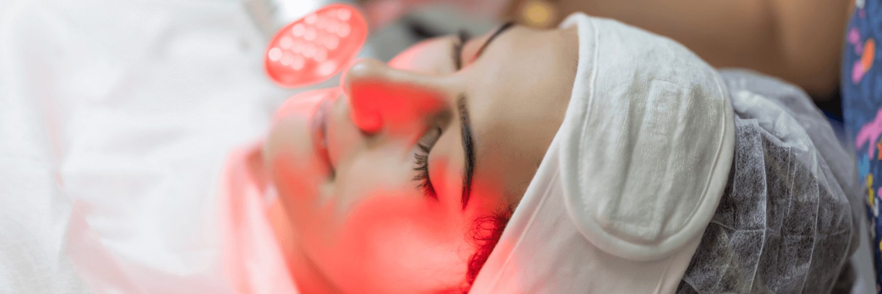 Woman receiving red light therapy facial treatment, highlighting potential effects on skin conditions like melasma