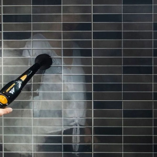 Using a steam cleaner to remove mould buildup from bathroom tiles and grout