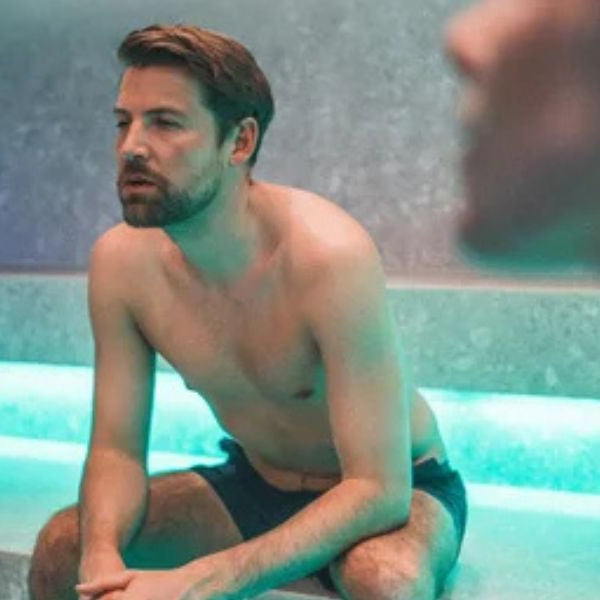 Man sitting in steam room with heavy steam highlighting heat and humidity levels