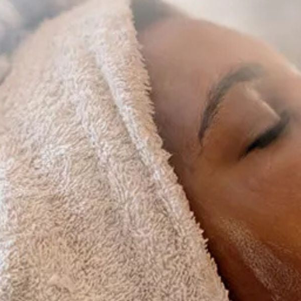 Close-up of woman’s face after steam room session, showing skin hydration and potential effects on pores