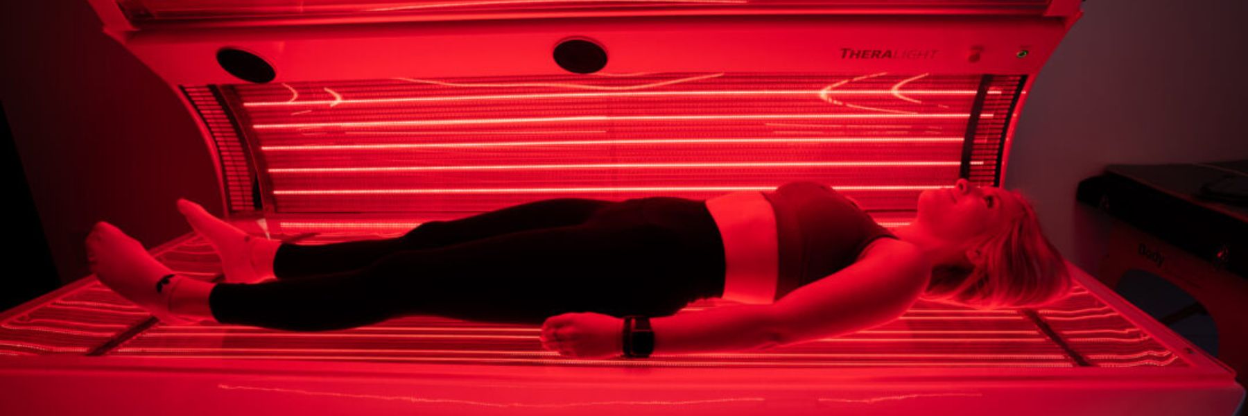 Woman wearing workout clothes during red light therapy session, demonstrating clothing impact on light absorption