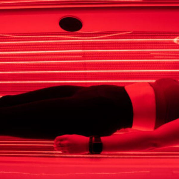 Woman wearing workout clothes during red light therapy session, demonstrating clothing impact on light absorption