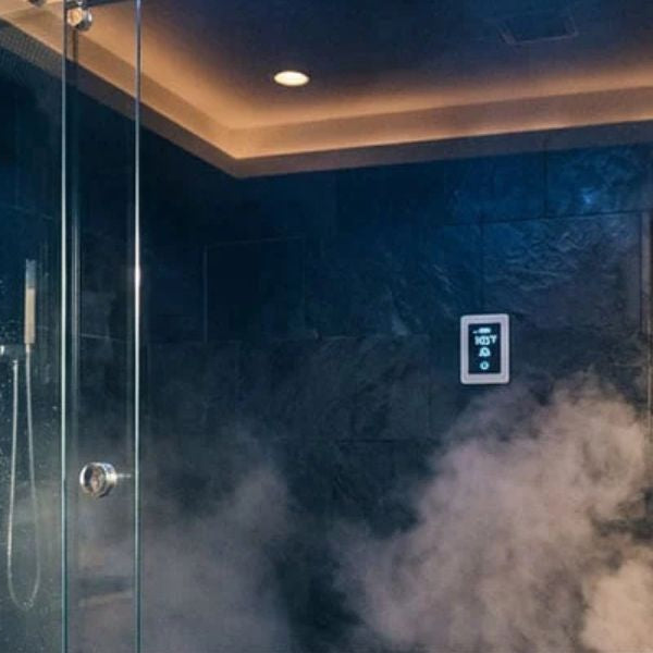Steam shower generating warm mist from built-in steam outlet in modern tiled bathroom