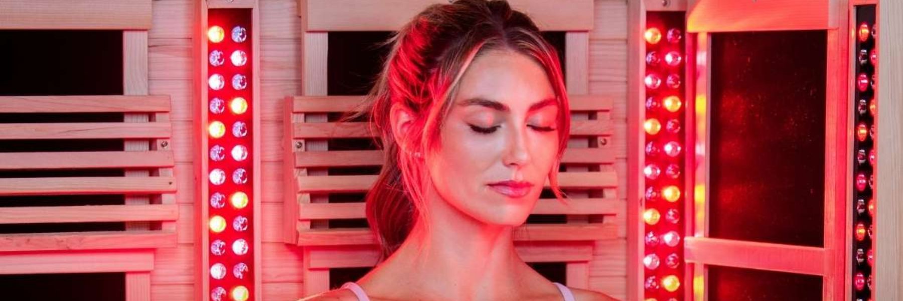 Woman using red light therapy in infrared sauna for skin rejuvenation and relaxation