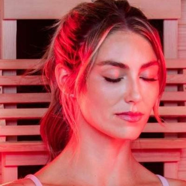 Woman using red light therapy in infrared sauna for skin rejuvenation and relaxation
