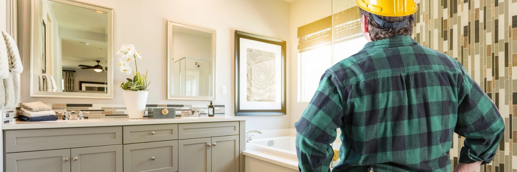 Contractor inspecting bathroom before installing a steam shower system in modern home