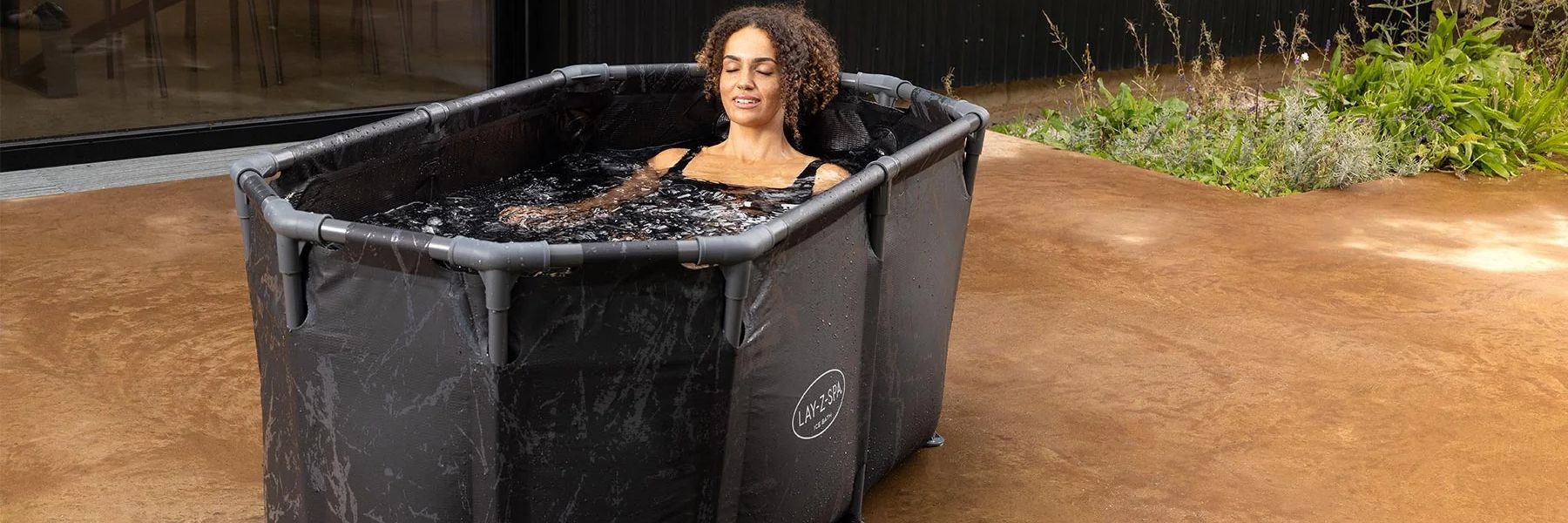 Preparing a cold plunge ice bath tub in a bathroom using bags of ice.
