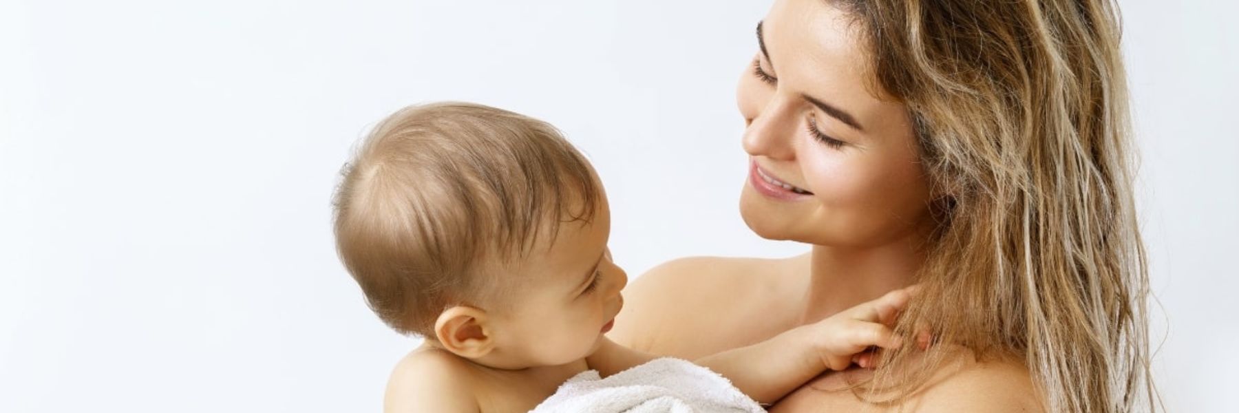 Mother holding baby after bath time showing gentle care and bonding at home