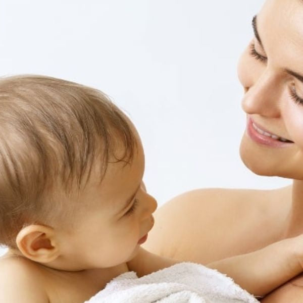 Mother holding baby after bath time showing gentle care and bonding at home