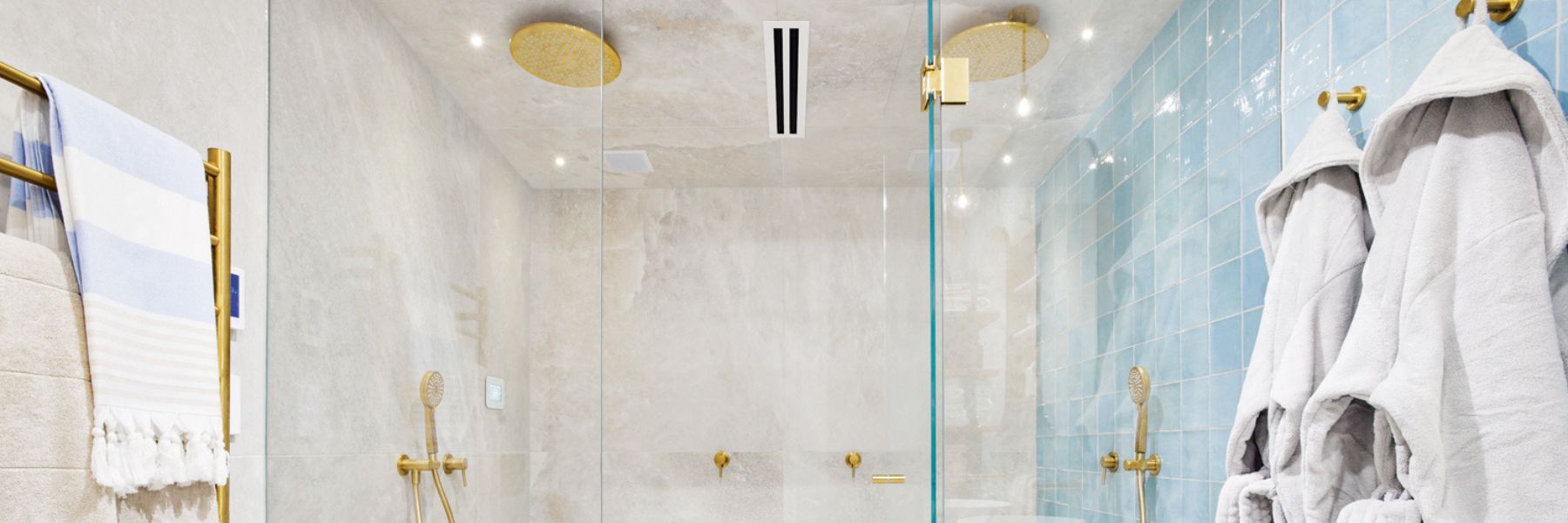 Modern steam shower with glass enclosure and rainfall showerhead in luxury bathroom