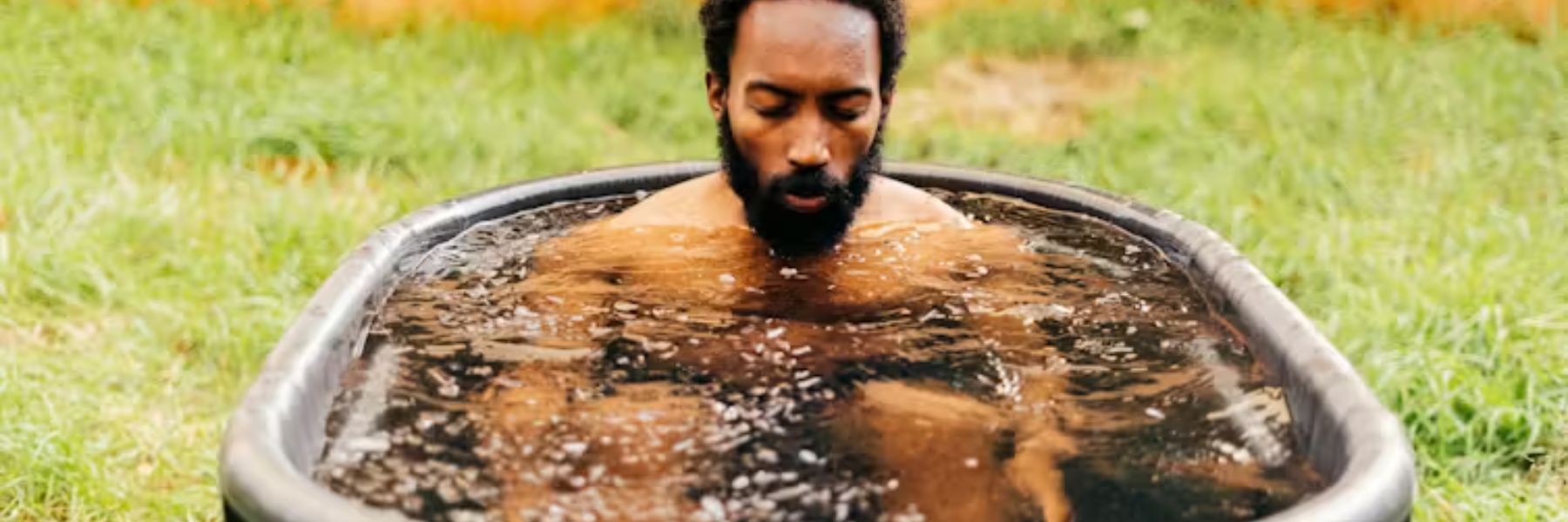 Outdoor cold plunge tub in a snowy garden used for ice bath wellness and recovery therapy.