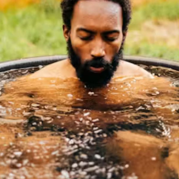 Outdoor cold plunge tub in a snowy garden used for ice bath wellness and recovery therapy.