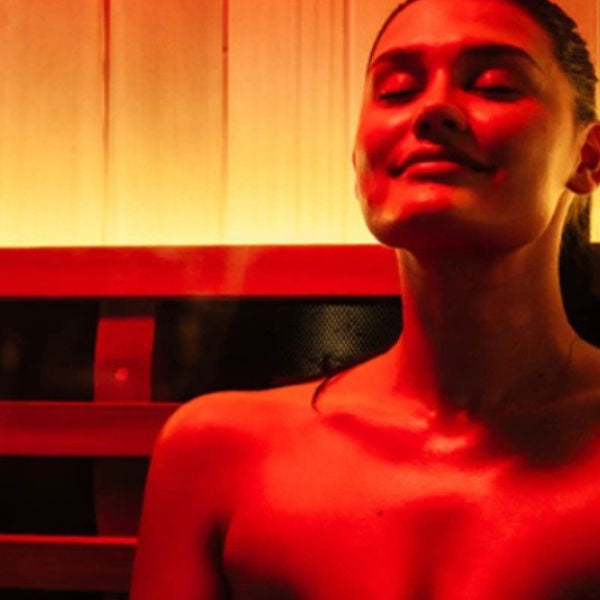 Woman in infrared sauna with red light therapy, supporting lymphatic drainage and detoxification