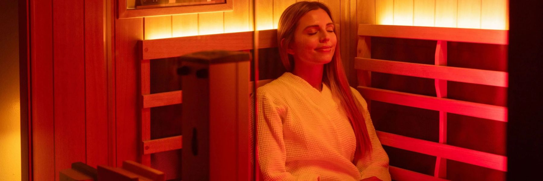 Woman relaxing in infrared sauna with red light therapy, promoting circulation and blood pressure benefits