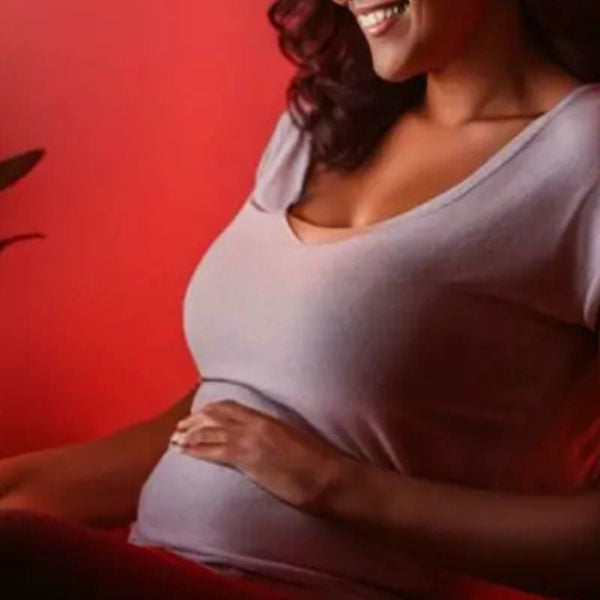Pregnant woman using red light therapy at home, exploring potential fertility and prenatal wellness support