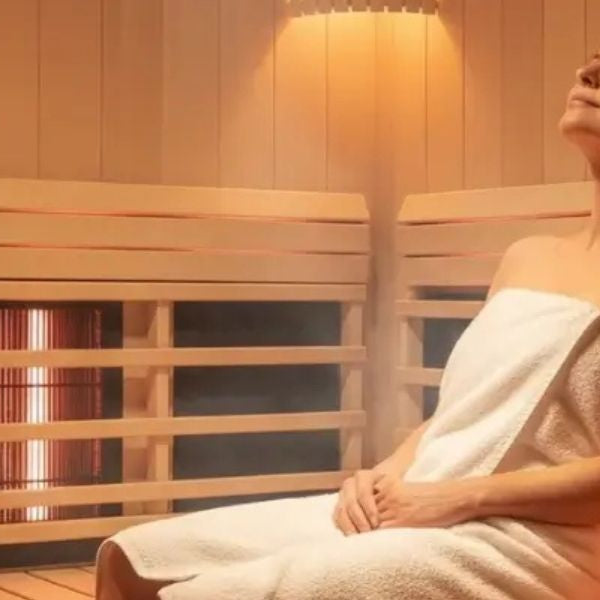 Woman resting in infrared sauna, promoting muscle recovery, reduced soreness, and relaxation