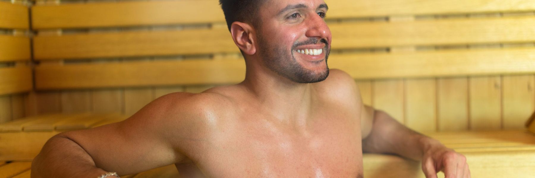 Man relaxing in traditional sauna, highlighting heat therapy and potential weight loss benefits