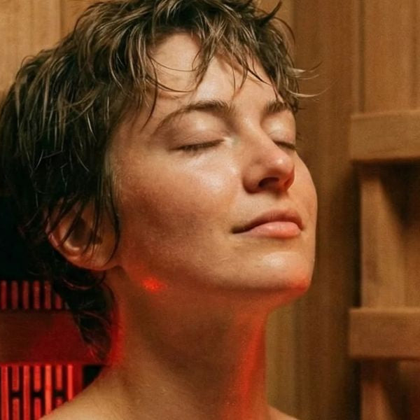 Woman using red light therapy in infrared sauna to soothe perioral dermatitis and reduce skin inflammation