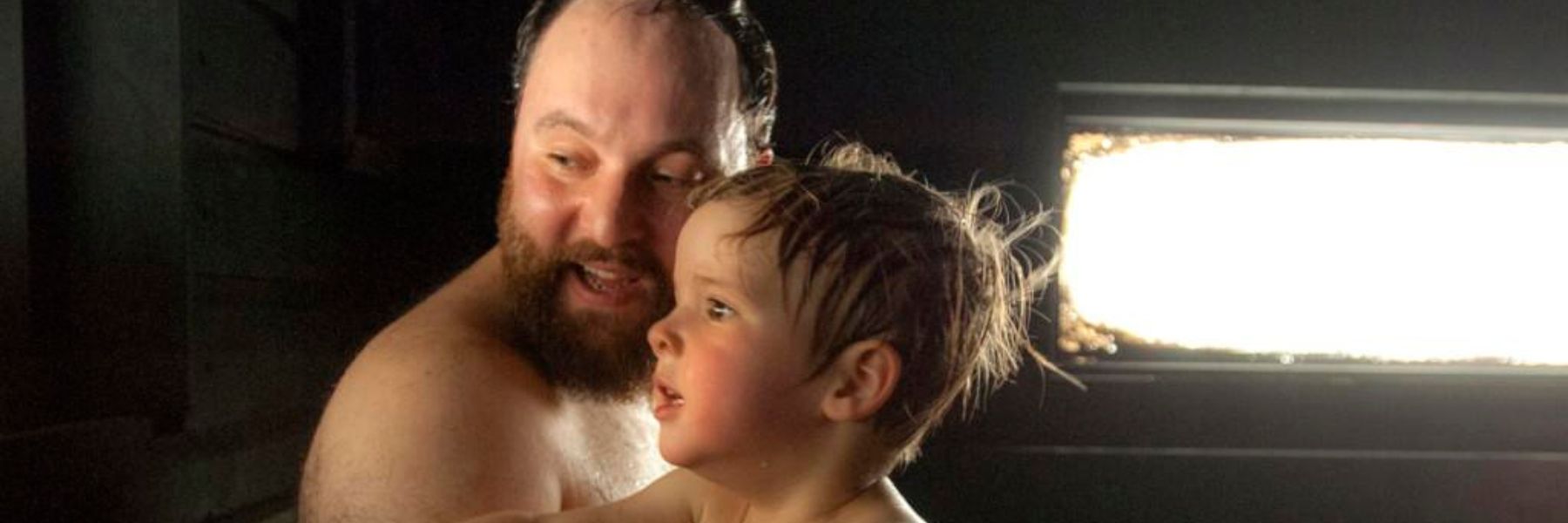 Parent holding toddler in a steam-filled room helping relieve croup symptoms and ease breathing