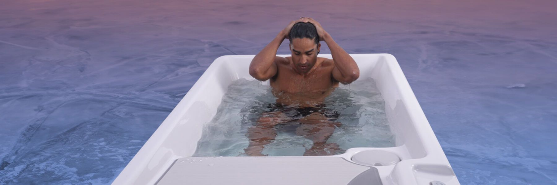 Man sitting in a cold plunge tub during an ice bath session for cold water therapy and recovery.