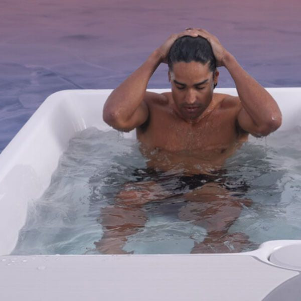 Man sitting in a cold plunge tub during an ice bath session for cold water therapy and recovery.