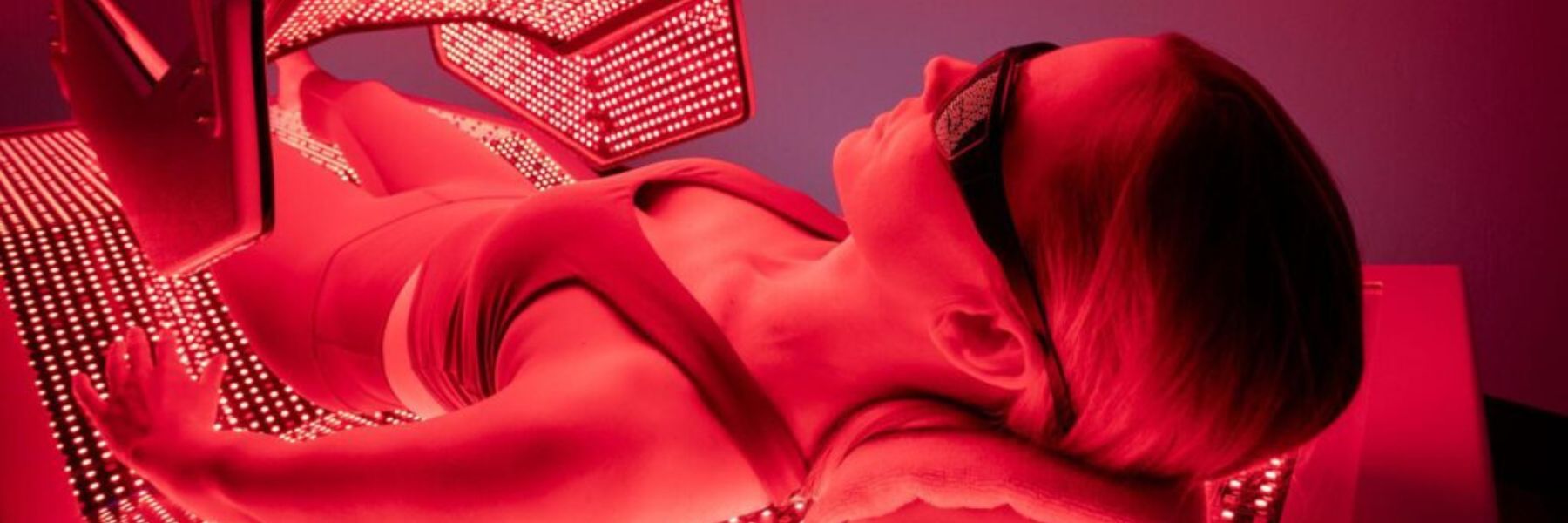 Woman undergoing full-body red light therapy session, demonstrating effective wavelengths for skin and recovery