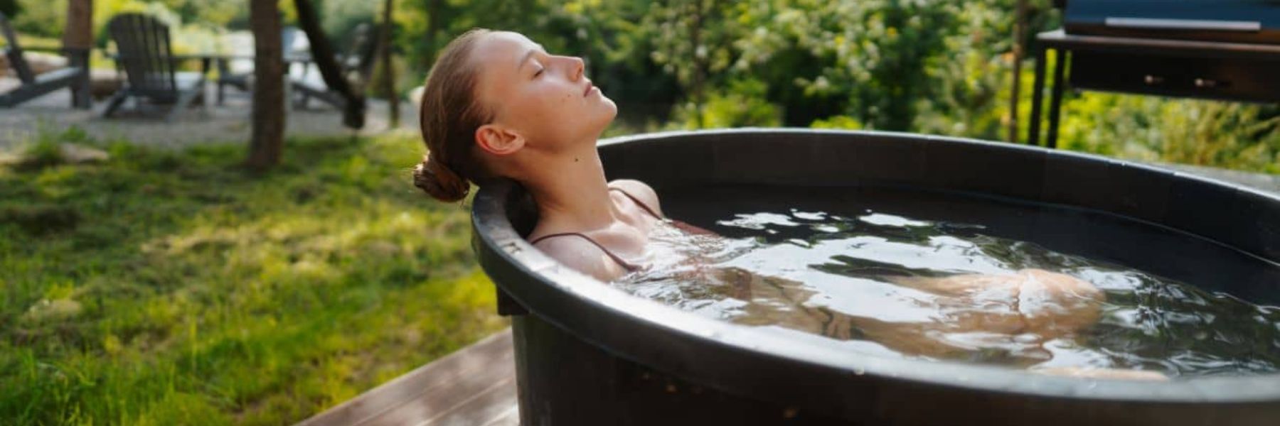 Person slowly entering a cold plunge tub while practising controlled breathing during cold exposure.