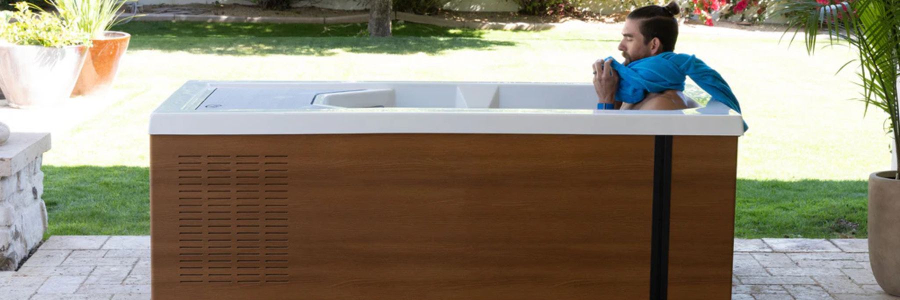 Person using a cold plunge tub outdoors in the morning to stimulate metabolism and support fat loss through cold water immersion.