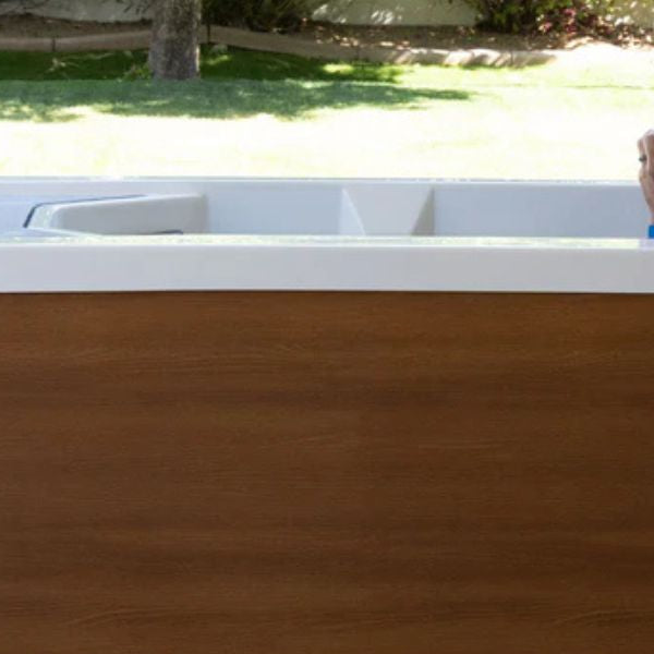 Person using a cold plunge tub outdoors in the morning to stimulate metabolism and support fat loss through cold water immersion.