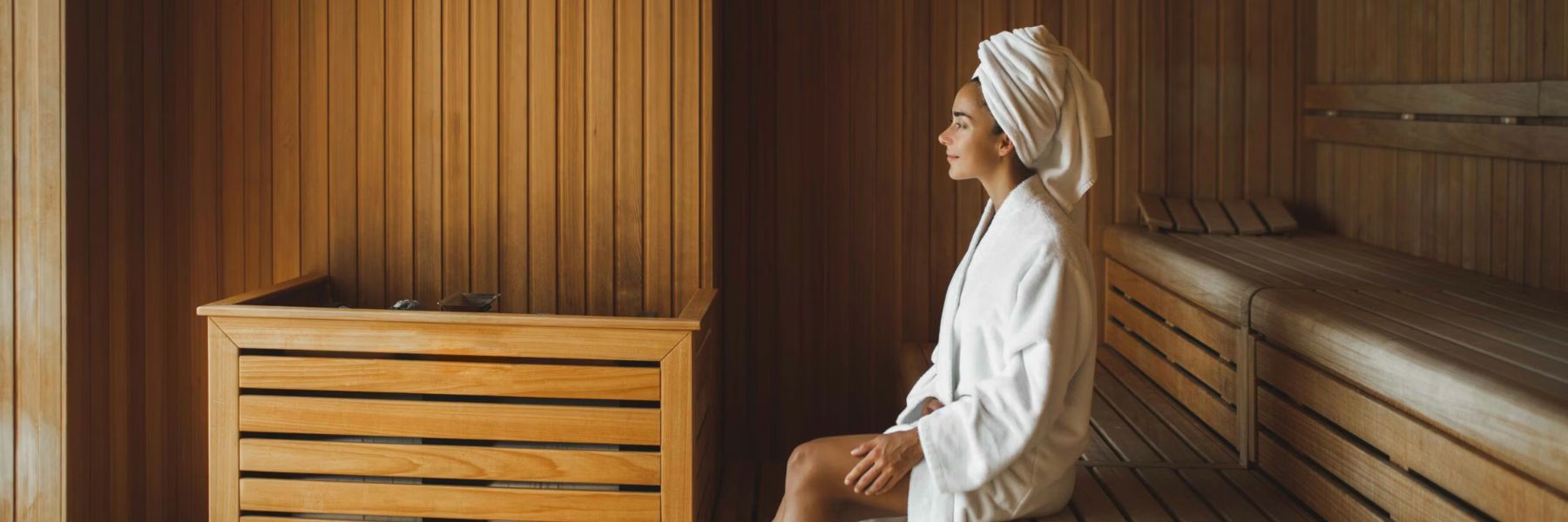 Woman enjoying steam room session with visible steam, illustrating best time to use a steam room for wellness
