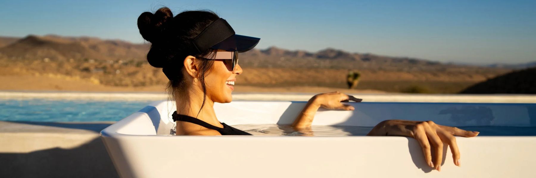 Woman relaxing in a cold plunge tub in the sun, showing contrast between perceived benefits and possible risks