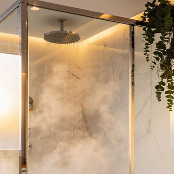 Modern steam shower enclosure in a luxury bathroom with warm lighting and steam for relaxation