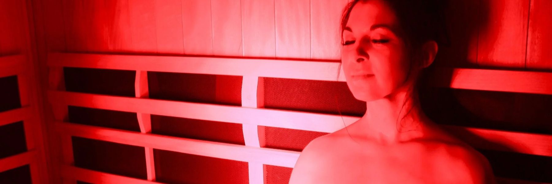 Woman using red light therapy in infrared sauna to help soothe eczema and reduce skin inflammation
