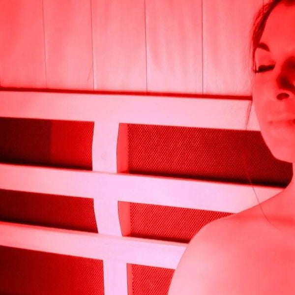 Woman using red light therapy in infrared sauna to help soothe eczema and reduce skin inflammation