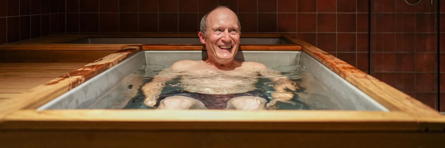 Outdoor cold plunge tub beside sauna used for contrast therapy and wellness routine.