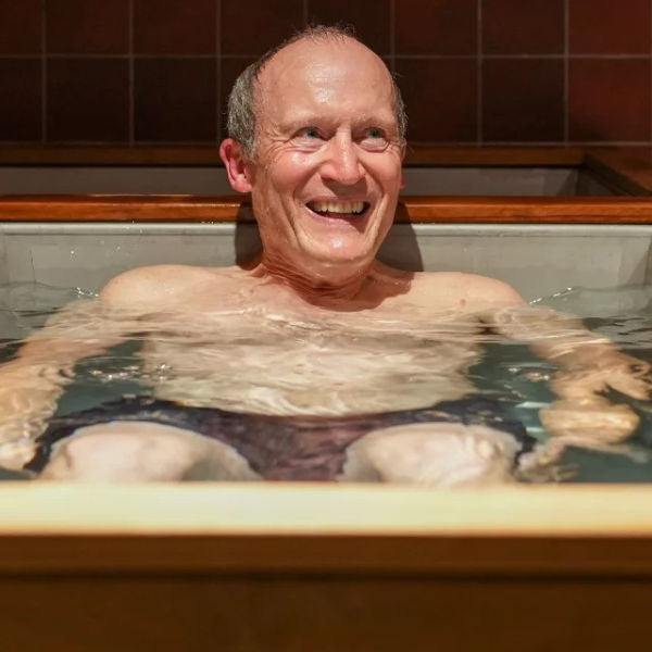 Outdoor cold plunge tub beside sauna used for contrast therapy and wellness routine.