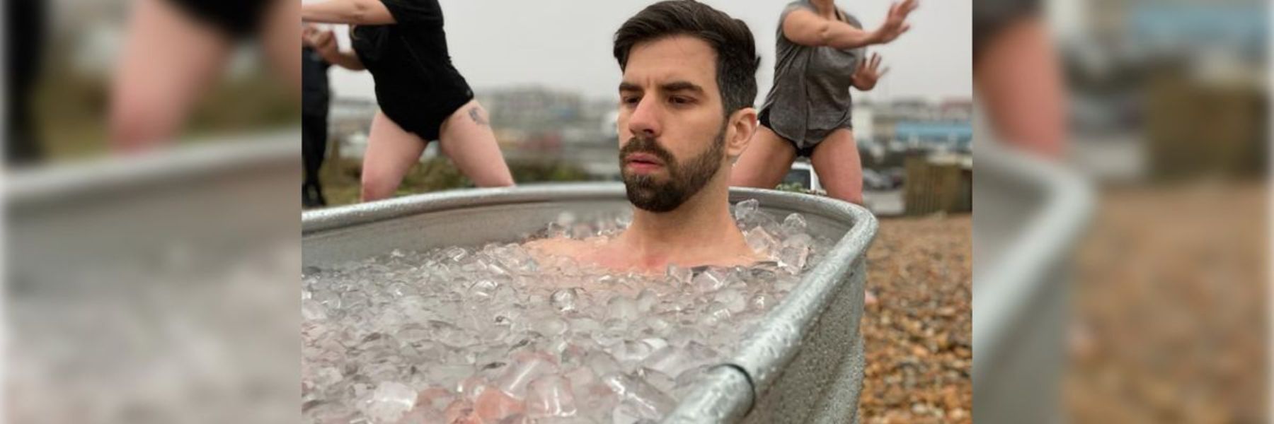 Athlete sitting in an outdoor ice bath tub during a cold plunge session for recovery and calorie burning.