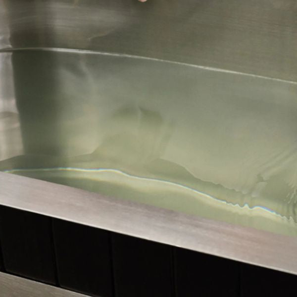 Cleaning the interior of a cold plunge tub during routine maintenance