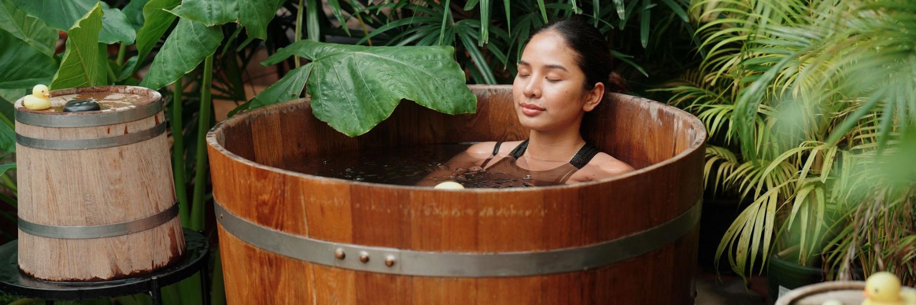 Adult athlete using an ice bath tub for cold plunge recovery therapy after exercise.