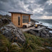 Dundalk CT Avalon outdoor cabin sauna on a rocky shoreline at dusk with a fire bowl