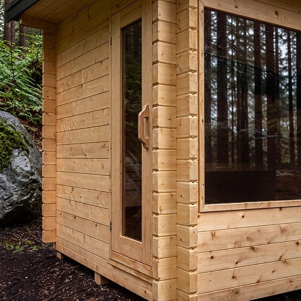 Detail of the CT Avalon 2 3/4 inch double-groove cedar log walls and glass door