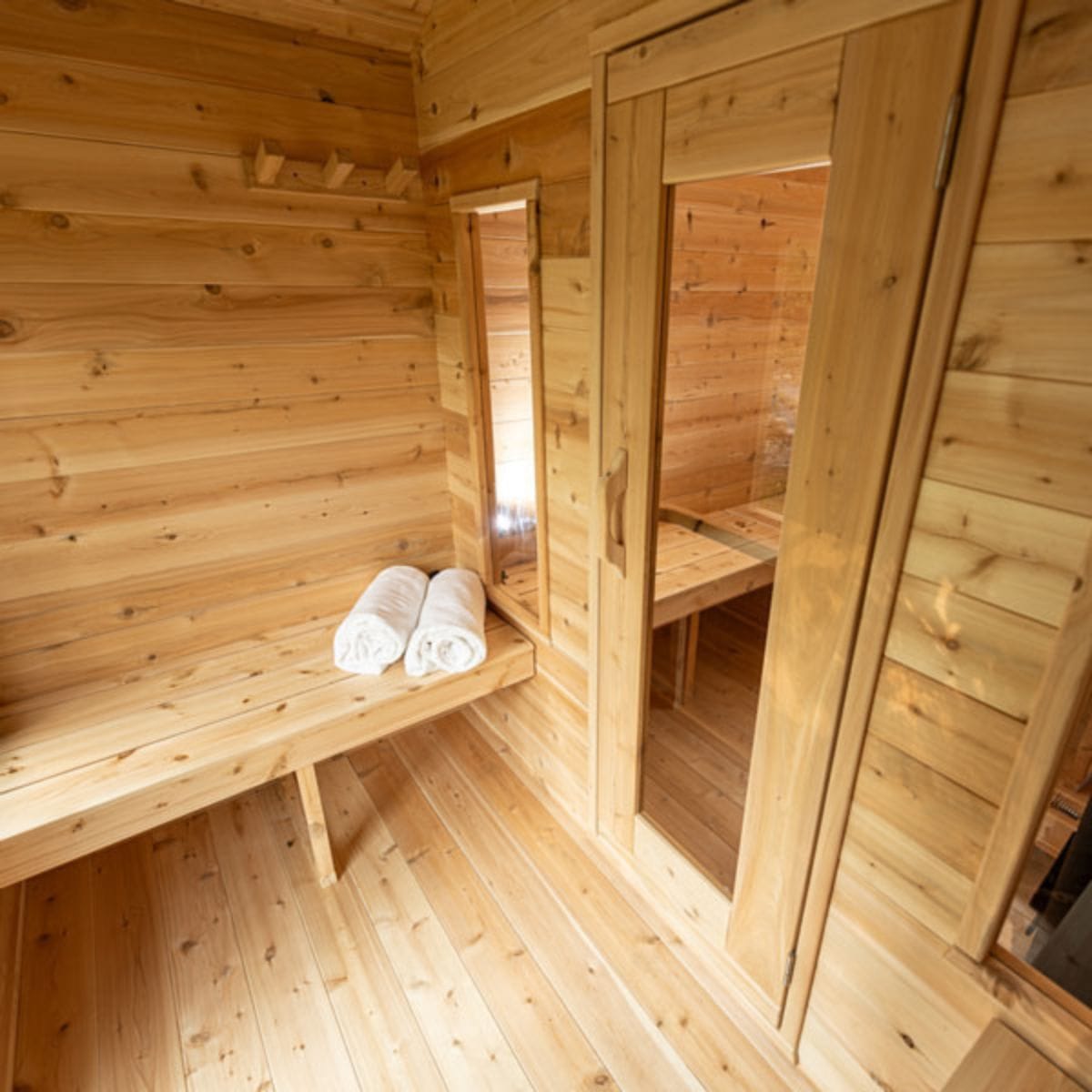 Wooden sauna interior with benches and towels