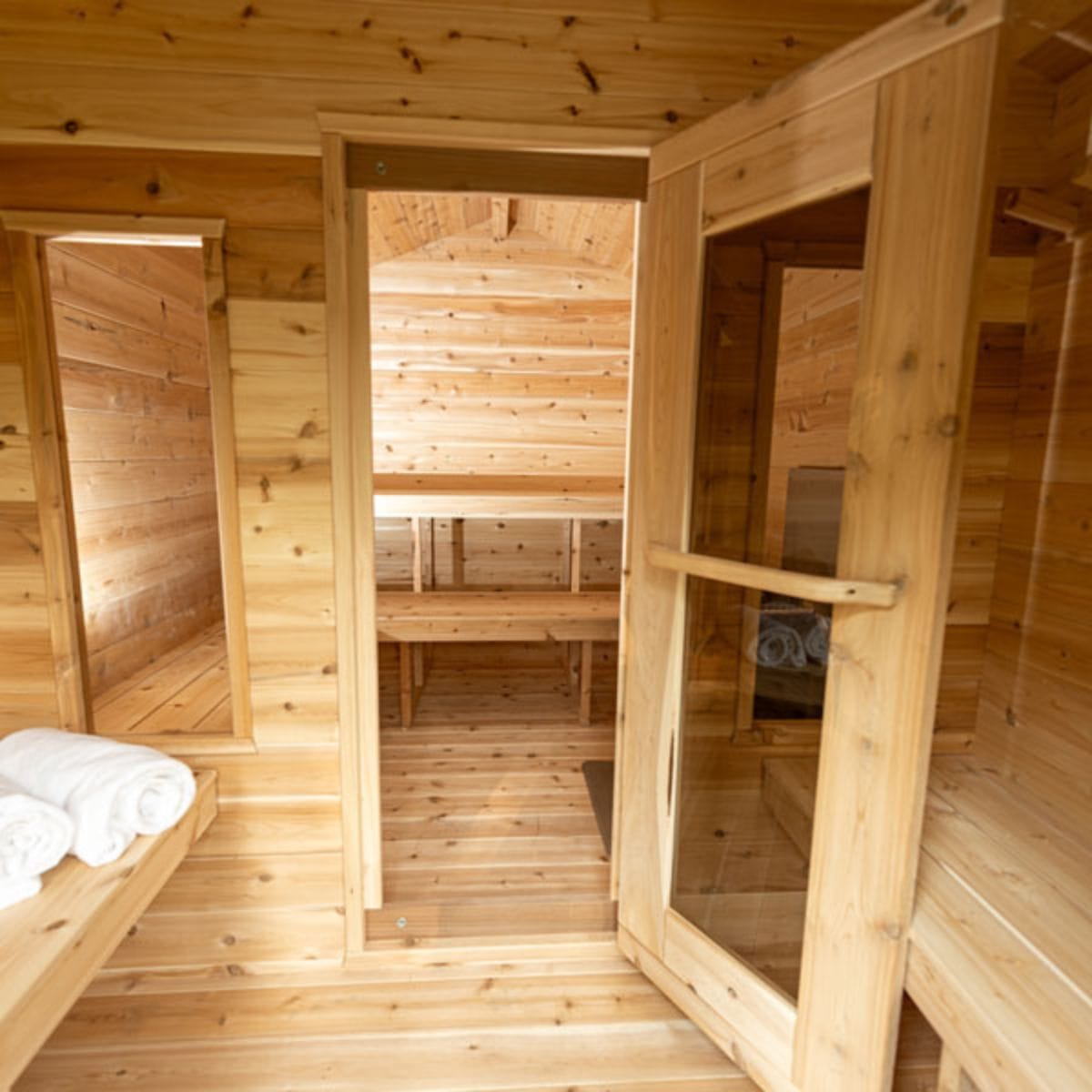 Wooden sauna interior with benches and towels